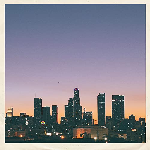 City skyline silhouette against a gradient sunset sky.