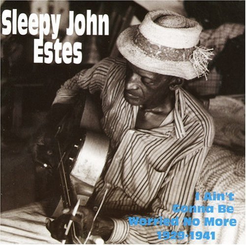 Black and white album cover with man playing guitar, wearing striped shirt and hat.