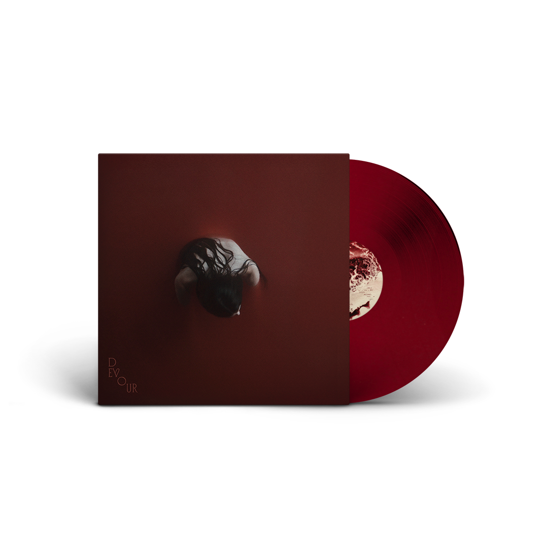 Red vinyl record and cover with a shadowy figure and text.