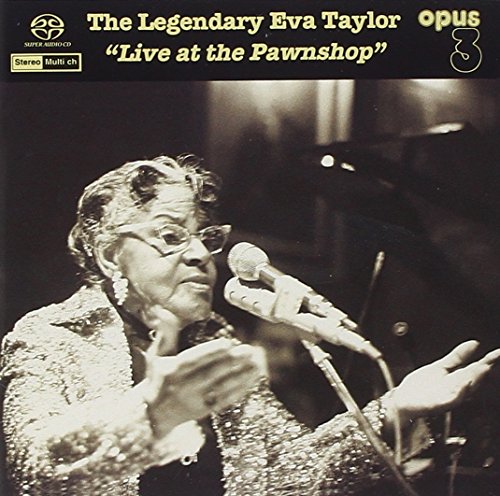 Black and white portrait of Eva Taylor singing into a microphone.