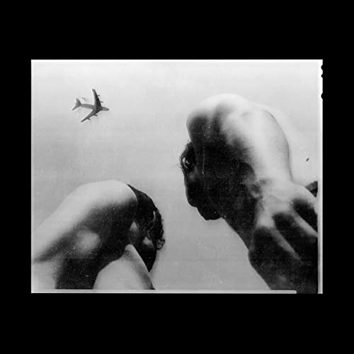 Black and white album cover featuring a person looking up at an airplane.