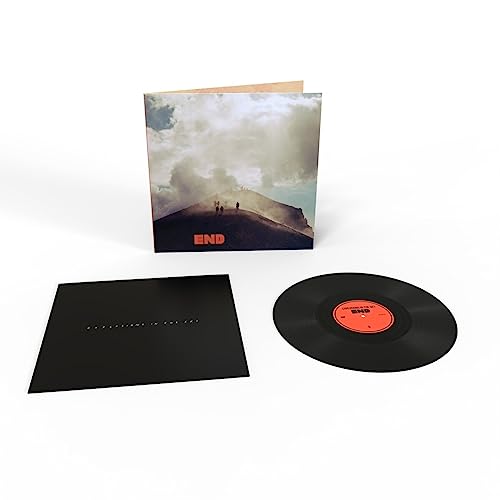 Vinyl record, black sleeve, and album cover showing figures on a hill.
