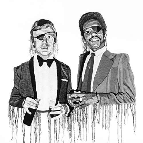 Black and white portrait of two men in suits wearing sunglasses.
