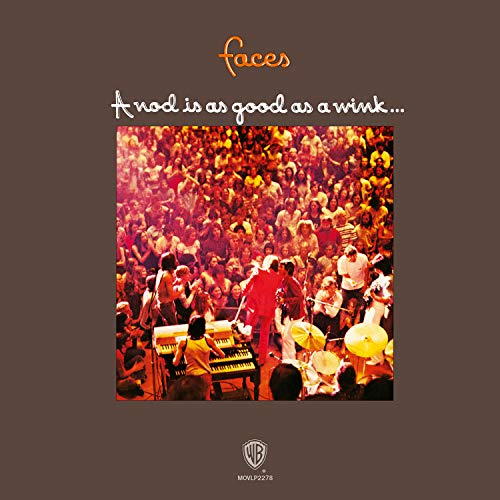 Album cover featuring a band performing live before a large crowd on brown background.