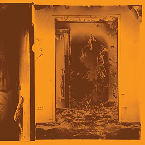 Square album cover with a distressed doorway in a decaying room.