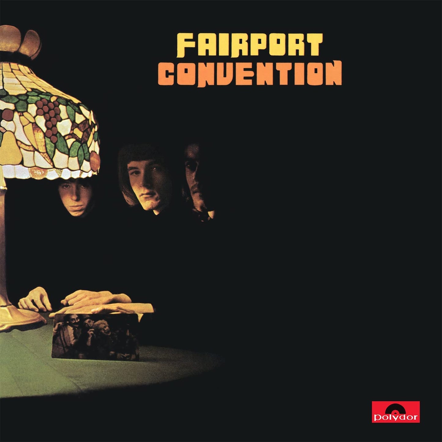 "Album cover with three band members under a lamp, 'Fairport Convention' in yellow and orange."