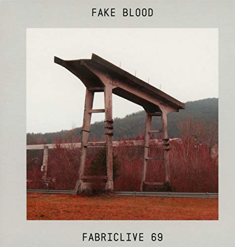 CD cover for "Fake Blood" featuring a weathered wooden structure and hills.