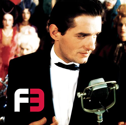 Man in tuxedo with microphone and logo for Falco 3 25th Anniversary.
