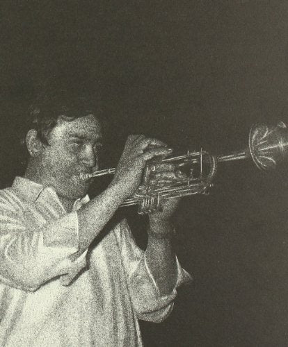 Black and white photo of a man playing a trumpet.