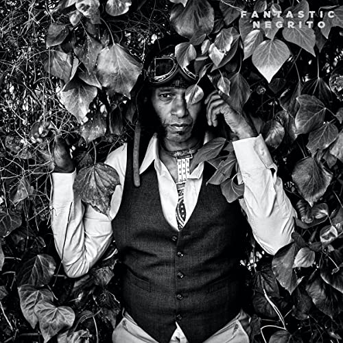 Black and white portrait of Fantastic Negrito amidst foliage.