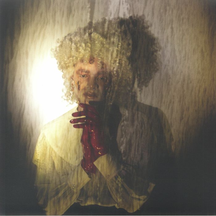 Person with curly hair and red gloves, blurred and stylized.