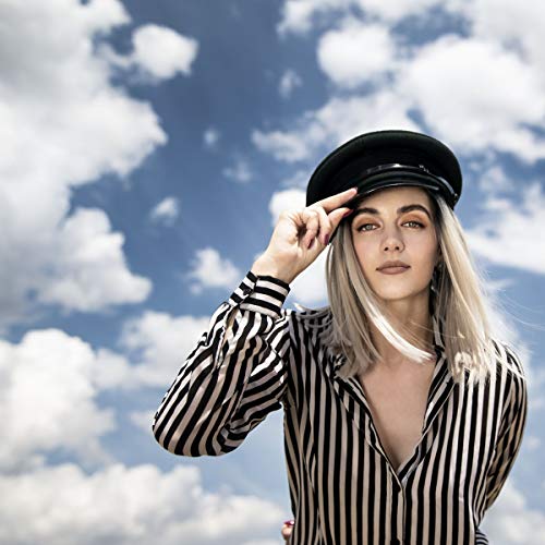 Woman with blonde hair wearing a captain’s hat and striped shirt.