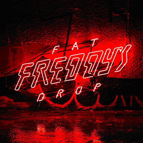 Bright red neon sign reading Fat Freddy's Drop against a dark, textured wall.