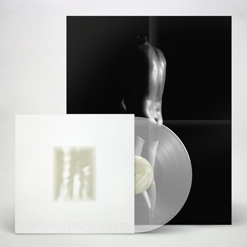 A white vinyl record sleeve and clear disc in front of a dark poster.