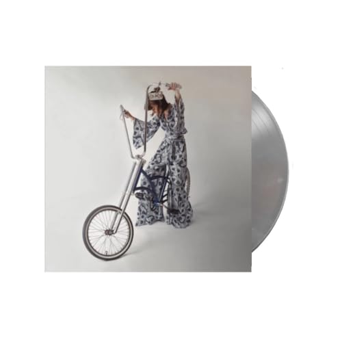 Woman in patterned robe poses with a vintage bicycle and vinyl record.