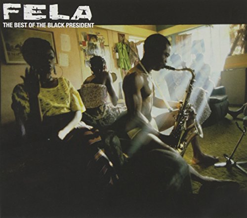 Fela Kuti playing saxophone in a dimly lit room with two women seated nearby.