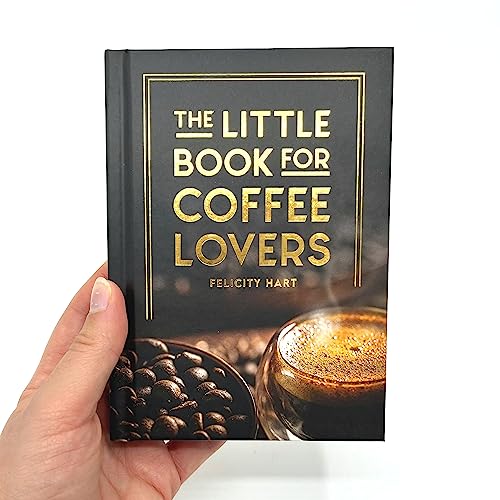 A hand holds a black book titled The Little Book for Coffee Lovers.