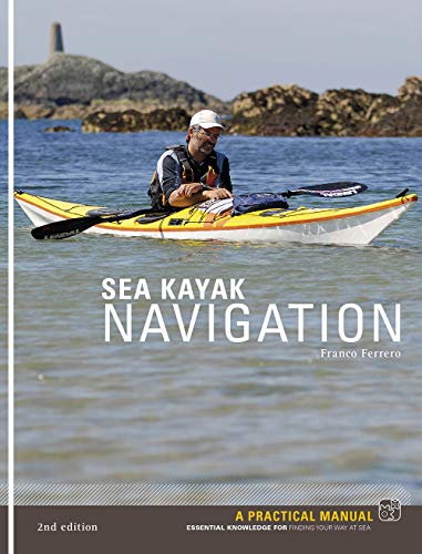 A man in a yellow kayak on the water with a rocky shoreline behind.