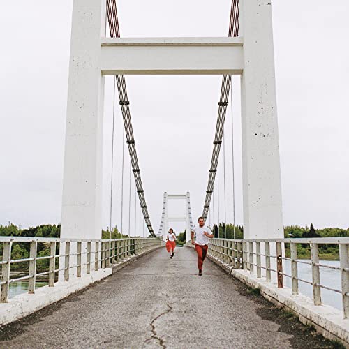 Two figures running on a long, white suspension bridge.