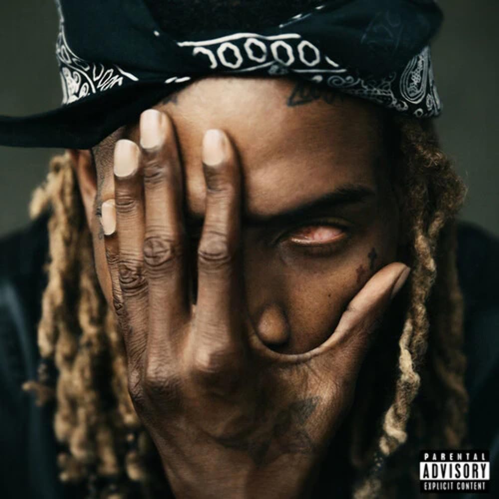 Fetty Wap wearing a bandana with his hand covering half of his face.