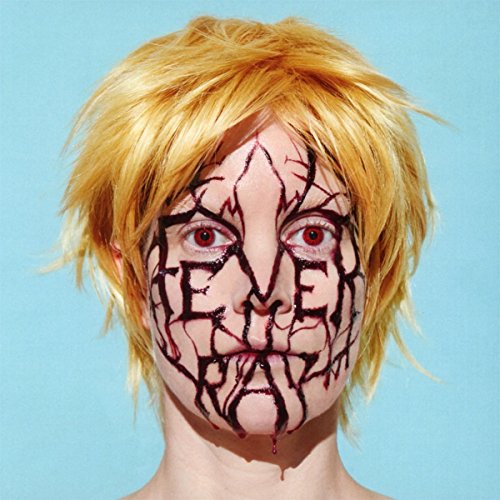 Person with cracked face makeup and red eyes, blonde wig, blue background.