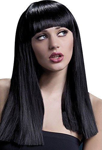 The image depicts a woman wearing a black wig with straight hair and bangs. Alt text: Woman wearing a black straight-haired wig with bangs against a dark background.