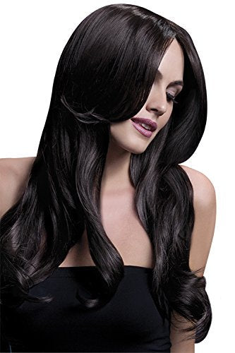 A woman with long, dark brown hair wearing a black strapless top against a dark blue background.