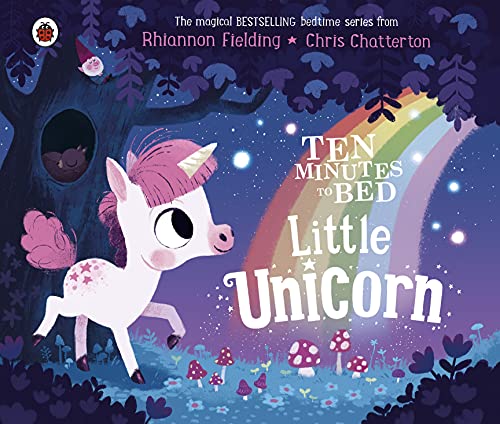 A white unicorn with a pink mane stands in a magical forest with a rainbow.
