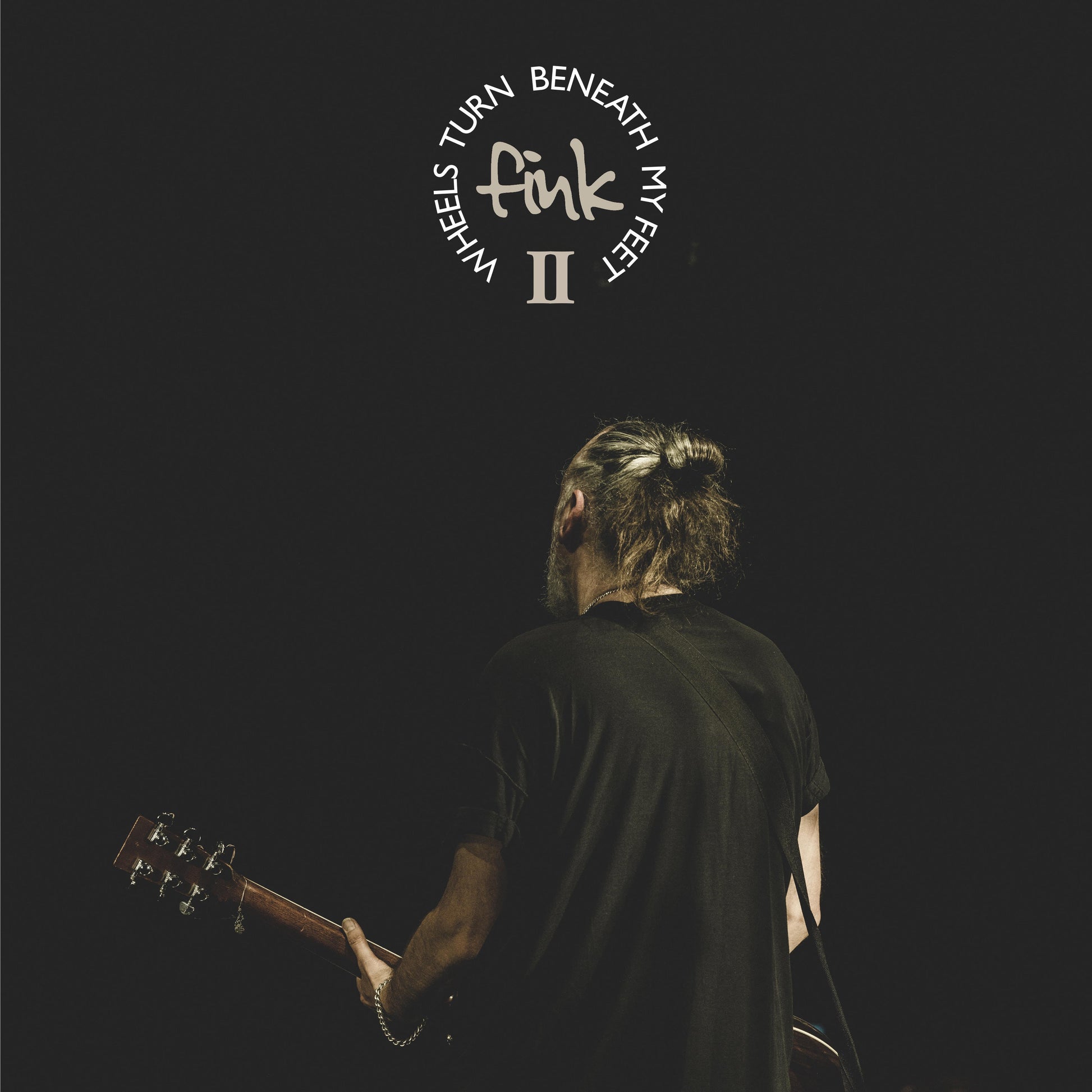 Album cover for Fink’s “Wheels Turn Beneath My Feet II” featuring a musician.