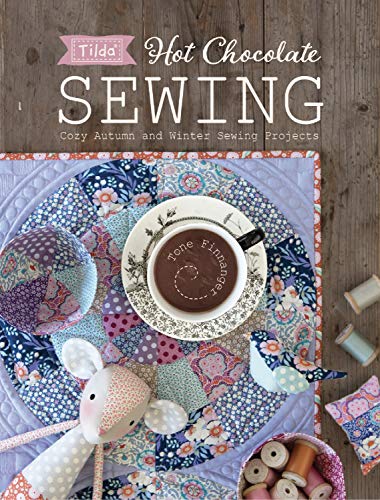 Book cover featuring a cup of hot chocolate, fabric crafts, and sewing materials.