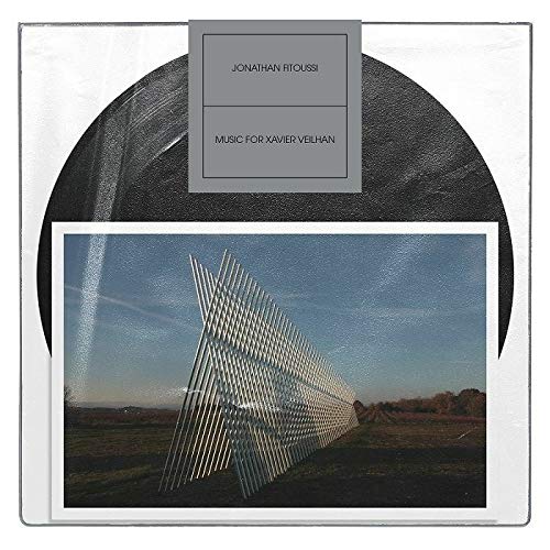 Vinyl record with album art depicting a modern, linear sculpture in a field.