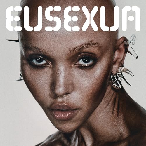 Close-up portrait of a bald person with sharp ear piercings and EUSEXUA text above.