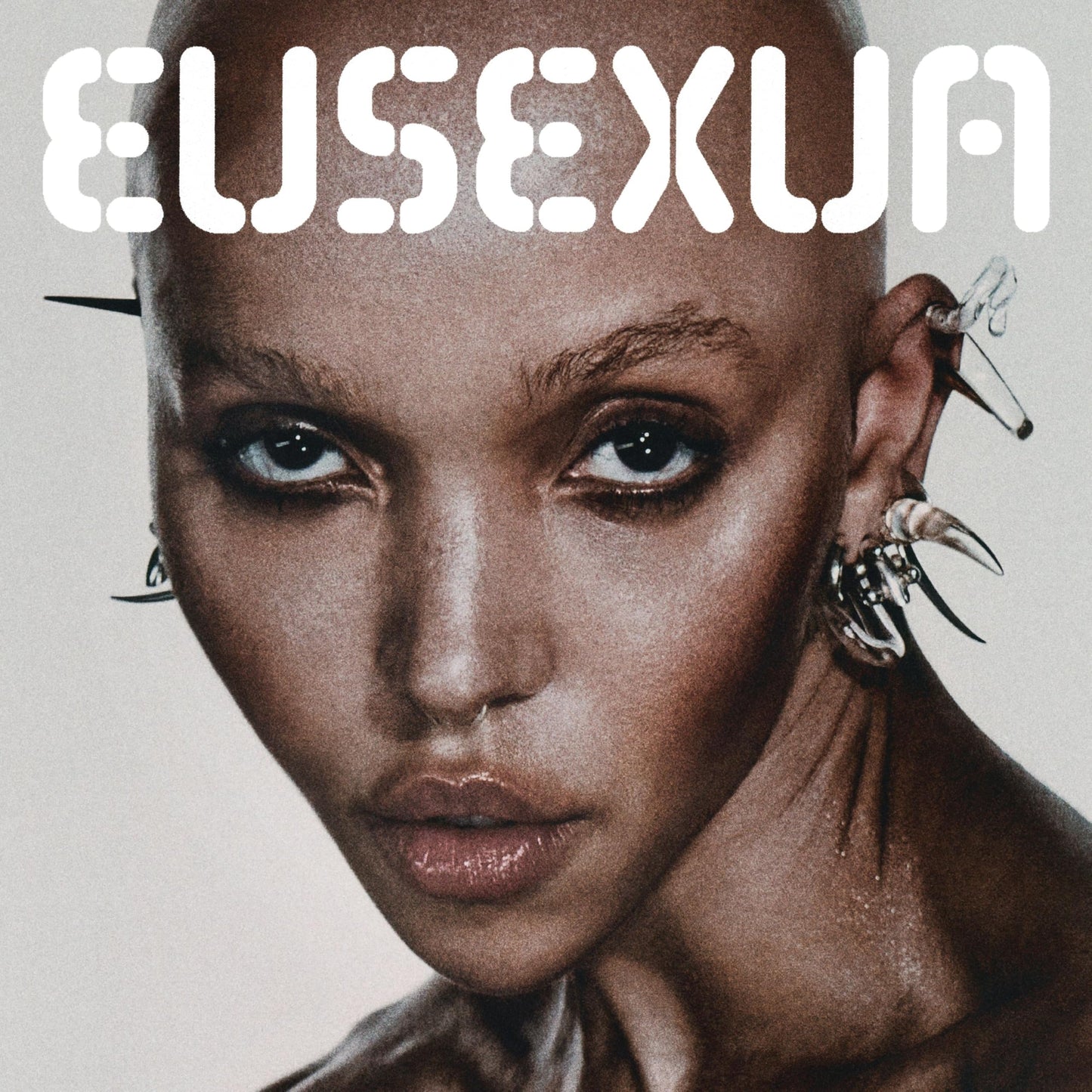 Fka Twigs album cover, close-up portrait with ornate ear jewelry.