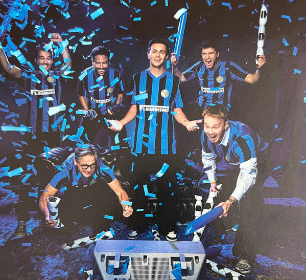 Soccer team in blue and black striped jerseys celebrating with confetti.