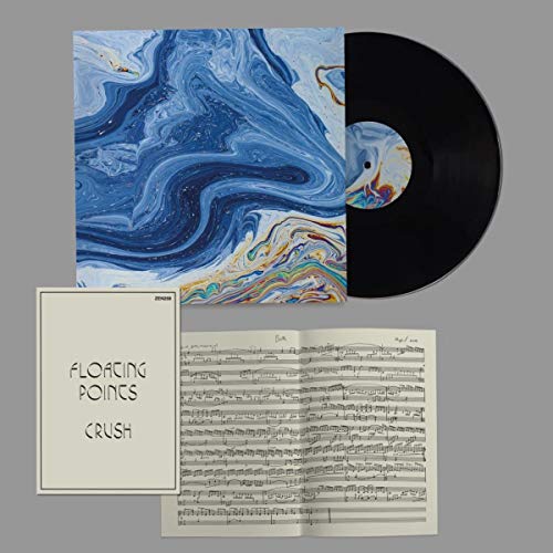 Vinyl record, album cover with blue swirls, and sheet music displayed.