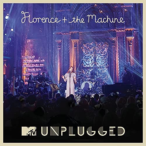 Florence Welch performing on stage with her band in front of an audience.
