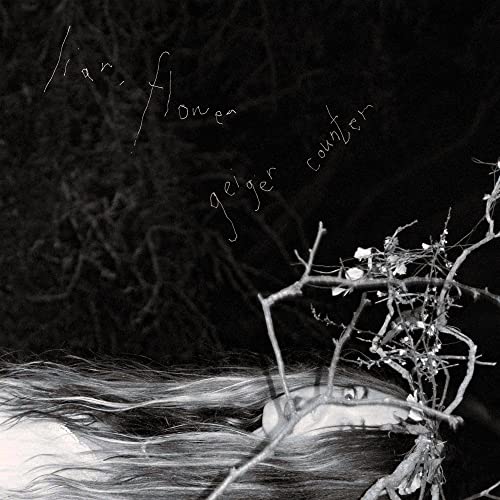 Black and white CD cover with branches, flowers, and a face obscured by hair.
