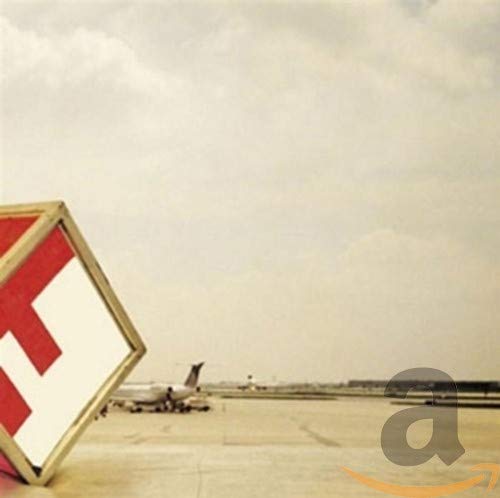 A red and white geometric shape in the foreground with an airport runway behind.