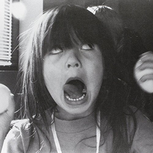 Black and white portrait of a young woman with an open mouth.