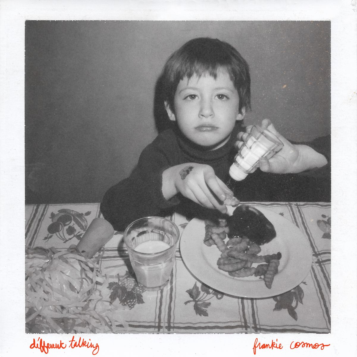 Black and white CD cover featuring a young child at a meal.