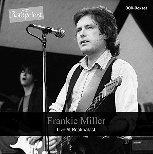 Black and white photo of Frankie Miller singing and playing guitar on stage.