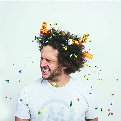 Man with curly hair covered in pills, expressing distress.
