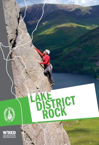 Rock climber on a cliff face overlooking a lake and mountains.