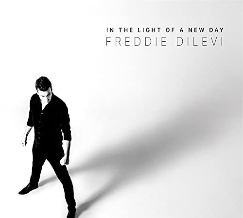 A man in black clothing stands against a white background with album title text.