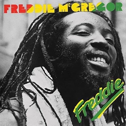 Black and white portrait of Freddie McGregor with dreadlocks, smiling, with colorful album text.