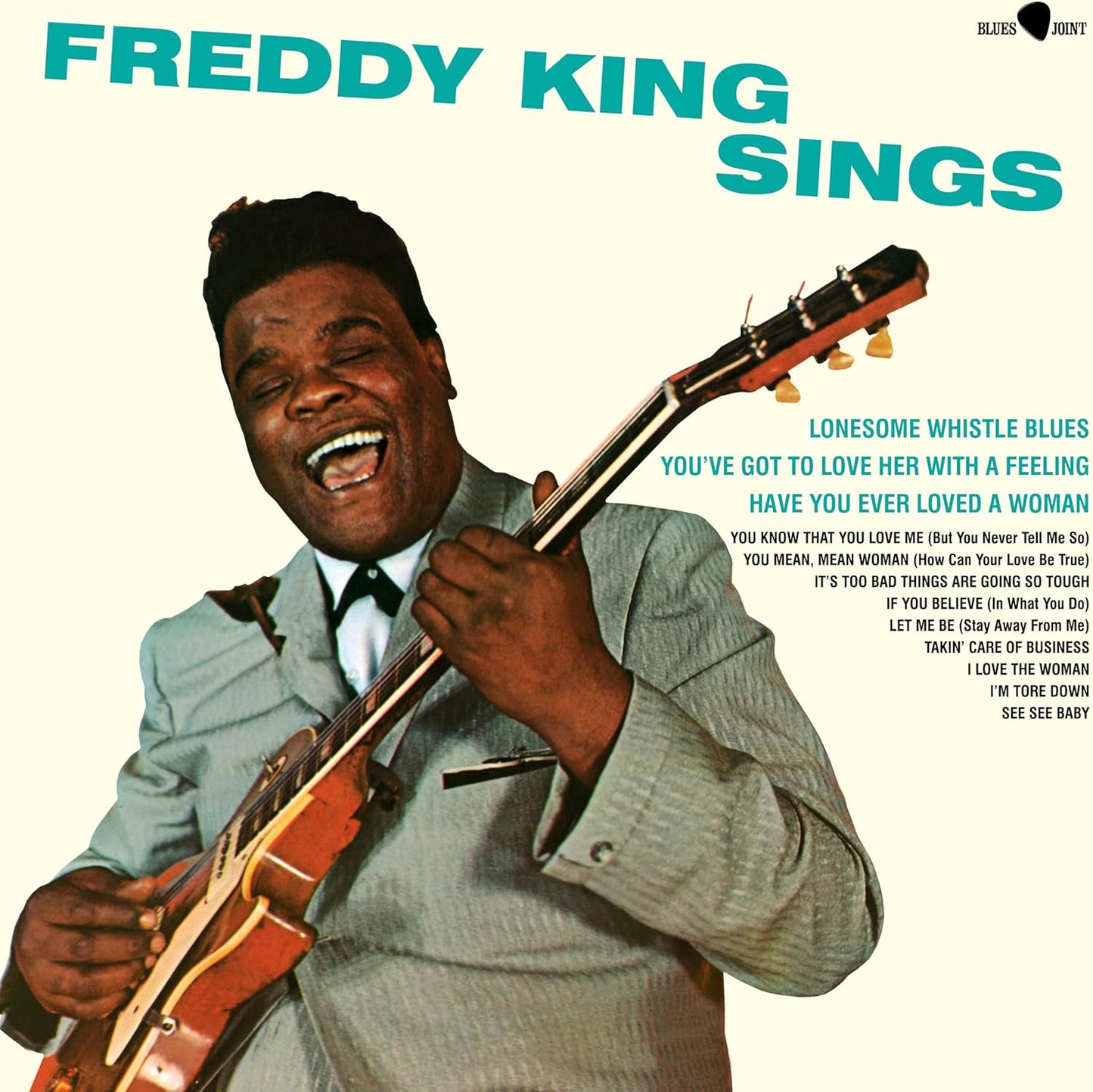 Freddy King album cover: smiling musician with a guitar, blue background.