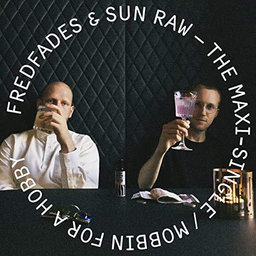 Record cover featuring two men raising drinks in a dark, textured setting.