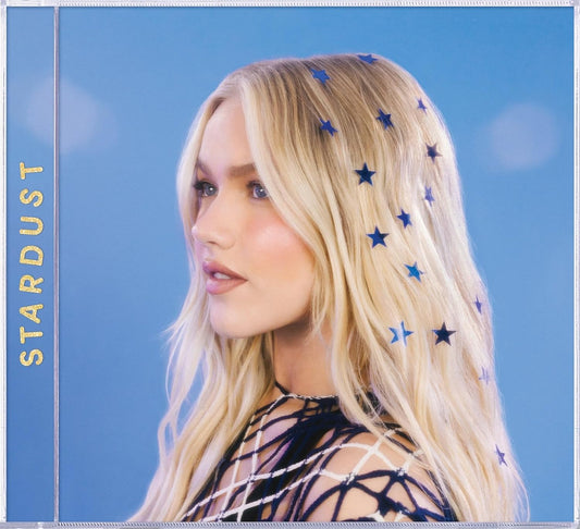Blonde woman with blue star stickers in her hair against a blue background.