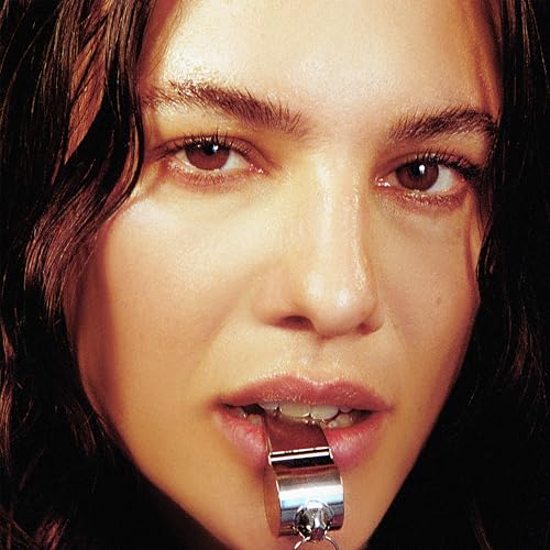 Close-up of a woman with a silver whistle held in her mouth.