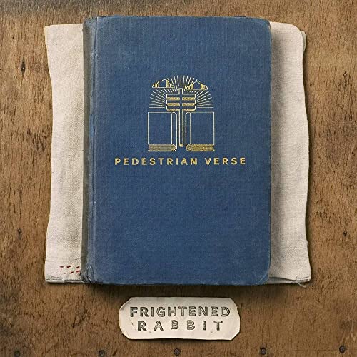 Blue book-shaped vinyl record cover with gold geometric design and text.